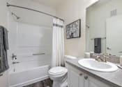 Thumbnail 11 of 38 - A white bathroom with a toilet, sink, and bathtub.