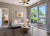 Thumbnail 5 of 38 - A living room with a white couch and a ceiling fan.