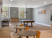 Thumbnail 9 of 35 - A community game room with a pool table and chairs.