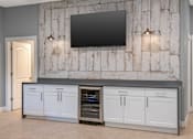 Thumbnail 11 of 35 - A modern kitchen with a large island and a flat screen TV mounted on the wall.