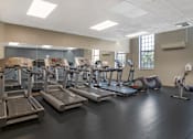 Thumbnail 14 of 35 - A gym with treadmills, elliptical machines, and other exercise equipment.