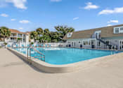 Thumbnail 18 of 30 - A large swimming pool in front of a building with a staircase leading down to it.