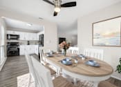 Thumbnail 8 of 30 - A modern dining room with a wooden table set for six.