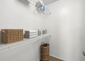 Thumbnail 6 of 30 - A white bathroom with a basket on the shelf.