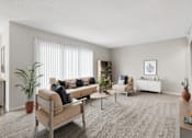 Thumbnail 2 of 30 - A living room with a beige sofa, a grey rug, and a white wall.