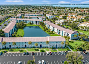 Thumbnail 28 of 30 - A large white building with a pool in front of it.