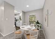 Thumbnail 6 of 27 - A dining room with a table set for two and a view of the backyard.