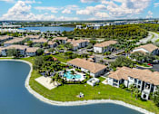 Thumbnail 31 of 32 - A bird's eye view of a residential area with a swimming pool and a lake.