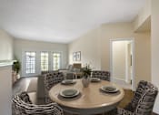 Thumbnail 16 of 32 - A dining room with a round table surrounded by chairs.