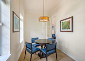 Thumbnail 27 of 32 - A dining room with a round table and chairs.