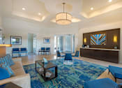 Thumbnail 26 of 32 - A living room with a blue rug and a white sofa.