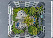Thumbnail 45 of 49 - A top-down view of a courtyard surrounded by buildings with a fountain in the center.