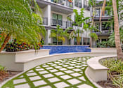 Thumbnail 21 of 49 - A modern building with a pool and a green lawn.