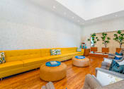 Thumbnail 35 of 49 - A living room with a yellow couch and a round ottoman.