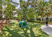 Thumbnail 41 of 49 - A playground with a green slide and a white building in the background.