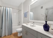 Thumbnail 5 of 49 - A white bathroom with a blue vase on the counter.