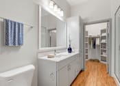 Thumbnail 11 of 49 - A bathroom with a white tub, sink, and wooden floor.