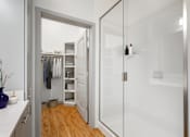 Thumbnail 12 of 49 - A white bathroom with a walk in shower and a white vanity.