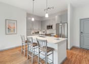 Thumbnail 2 of 49 - A kitchen with a white countertop and stainless steel appliances.