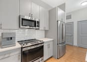 Thumbnail 3 of 49 - A modern kitchen with stainless steel appliances and white cabinets.