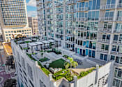Thumbnail 29 of 48 - A modern building with a green roof and a glass balcony.