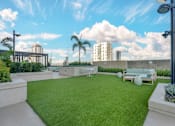 Thumbnail 24 of 48 - A rooftop garden with a white bench and a green lawn.