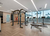 Thumbnail 19 of 48 - A gym with a variety of equipment including a treadmill, a stationary bike, and a rowing machine.