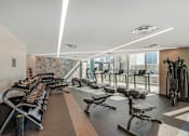 Thumbnail 18 of 48 - A gym with a variety of equipment including treadmills, weights, and exercise machines.