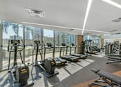 Thumbnail 17 of 48 - A gym with treadmills, elliptical machines, and other exercise equipment.
