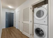 Thumbnail 15 of 48 - A laundry room with a washer and dryer stacked on top of each other.