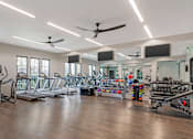 Thumbnail 13 of 49 - A gym with treadmills, exercise bikes, and other equipment.