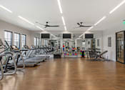 Thumbnail 14 of 49 - A gym with treadmills, exercise bikes, and other equipment.
