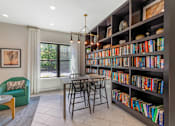 Thumbnail 39 of 49 - A room with a large bookshelf filled with books and a table with chairs.