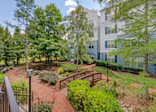 Thumbnail 21 of 49 - A courtyard with a brick pathway and a metal railing.