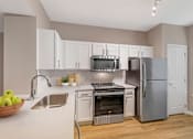 Thumbnail 7 of 49 - A kitchen with a stainless steel refrigerator, oven, and microwave.