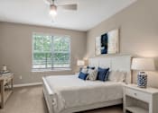 Thumbnail 4 of 49 - A bedroom with a large bed, a ceiling fan, and a window with blinds.