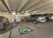 Thumbnail 43 of 49 - A parking garage with a green electric vehicle charging station sign.