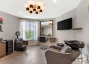 Thumbnail 41 of 49 - A modern living room with a grey sofa and a black television.