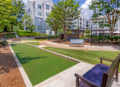 Thumbnail 17 of 49 - A park with a bench and a green lawn.