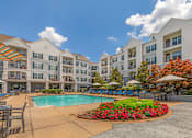 Thumbnail 12 of 49 - A large white building with a pool in front.