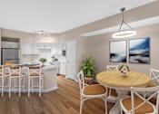 Thumbnail 1 of 49 - A modern kitchen with a dining table set for four.