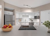 Thumbnail 2 of 49 - A kitchen with a bowl of fruit on the counter.