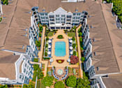 Thumbnail 44 of 49 - A large building with a pool in the middle of a courtyard.