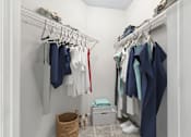 Thumbnail 6 of 34 - A white closet with clothes hanging on a rack.