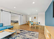 Thumbnail 21 of 34 - A living room with a blue couch and a rug.