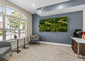 Thumbnail 19 of 34 - A living wall with plants in a grey room with a grey chair and a table.