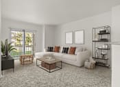 Thumbnail 8 of 34 - A living room with a white couch, a coffee table, and a plant.