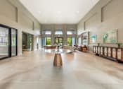 Thumbnail 21 of 33 - A spacious lobby with a large wooden table in the center.