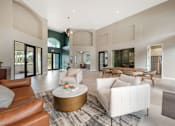 Thumbnail 22 of 33 - A modern living room with a white sofa and a gold coffee table.