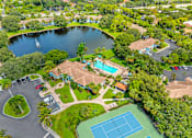 Thumbnail 33 of 33 - A bird's eye view of a resort with a tennis court, swimming pool, and a lake.